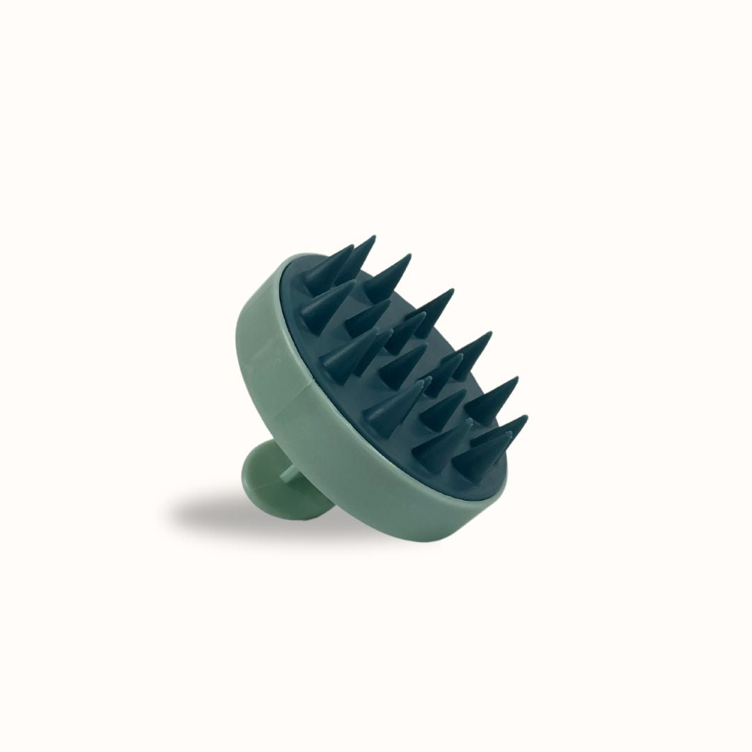 Green scalp massager with spikes on a white background